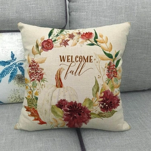 Macro shot of rustic linen pillowcase with pumpkin floral wreath and Welcome Fall text