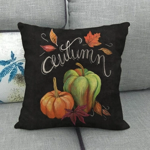 Black linen pillowcase with hand-painted pumpkins and Autumn lettering on a sofa