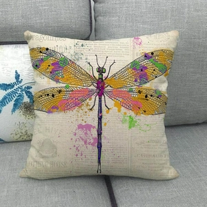 Détail de la housse de coussin en lin à motif libellule sur un canapé gris au style vintage