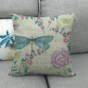 Housse de coussin en lin avec motif libellule et fleurs sur un canapé gris chic