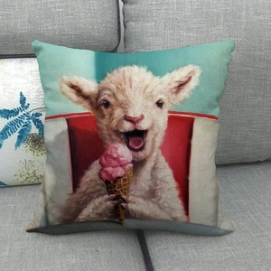 Detail of linen pillowcase featuring a cute sheep eating pink ice cream on a blue sofa
