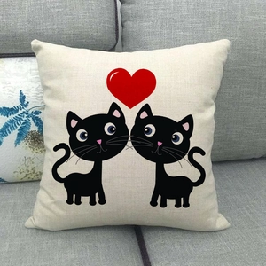 Detailaufnahme von Leinenkissenbezug mit schwarzen Katzen und rotem Herz auf Sofa