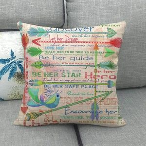 Detail of linen pillowcase with bird and arrow prints on a gray fabric sofa
