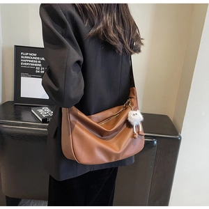 Brown lychee grain soft leather dumpling bag with white plush charm and wide strap