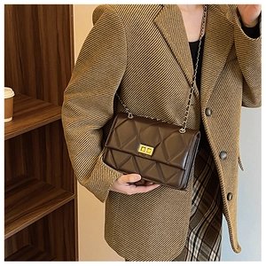Détail du sac bandoulière matelassé marron chocolat avec un fermoir rotatif doré