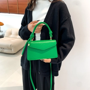 Green lychee pattern crossbody bag with golden hardware and adjustable strap shown on model