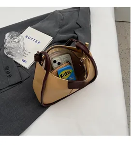 Top view of spacious bucket bag interior showing phone and mint box on grey blazer