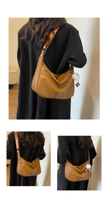 Brown moon-shaped crossbody bag with soft lychee texture and plush pendant detail