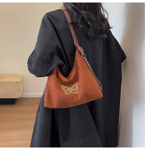 Detailed view of vintage brown tote featuring elegant golden butterfly embroidery and chain strap