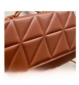 Détail du sac à bandoulière marron en similicuir matelassé avec chaîne épaisse assortie