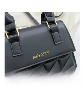 Close-up of black quilted PU leather texture with gold ring buckle and fine stitching