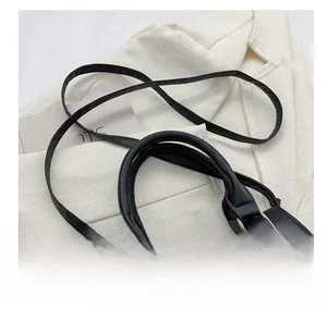 Detail of comfortable shoulder strap and golden buckle on black leather handbag