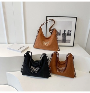Detailed macro view of vintage butterfly printed suede bags with silver chain straps