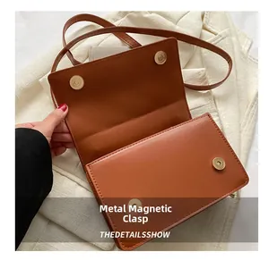 Détail de la fermeture magnétique en métal sur le sac à bandoulière en similicuir marron