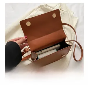 Vue intérieure d'un sac bandoulière en cuir marron montrant sa capacité de rangement
