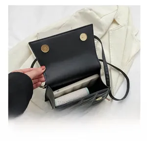 Interior view of black quilted crossbody bag showing capacity for phone and wallet