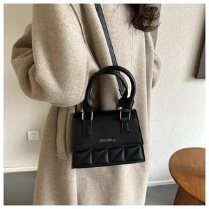 Détails du sac bandoulière noir avec ferrures dorées et texture élégante matelassée