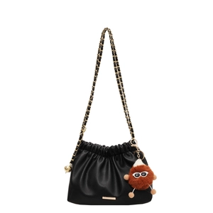Large capacity black soft leather drawstring shoulder bag with a cute monster keychain
