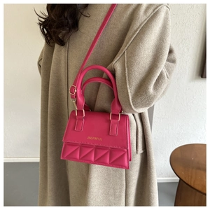Sac bandoulière en cuir PU fuchsia avec rabat matelassé et logo doré sur manteau beige