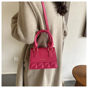 Détail du sac bandoulière rose fuchsia avec matelassage losange et finitions dorées chic