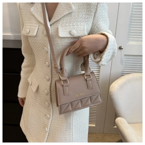 Detailed view of nude rhombic texture PU leather handbag with gold metal hardware