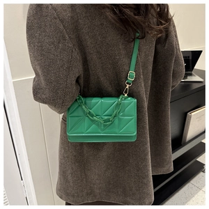 Vue détaillée d'un sac à bandoulière matelassé vert avec chaîne épaisse et boucle dorée chic