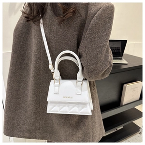 Detailed side view of a white PU leather mini bag with diamond quilting and top handle
