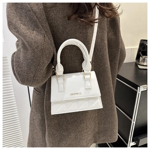 White quilted PU leather crossbody bag worn with a dark brown suit for daily style