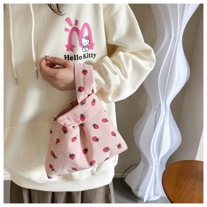 Détail du sac à main en velours côtelé rose à motif fraise avec poignée nouée
