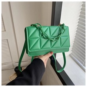 Vue détaillée du sac carré vert vif matelassé avec une décoration de chaîne épaisse
