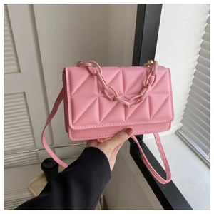 Gros plan du sac bandoulière rose matelassé avec chaîne élégante et texture en cuir PU