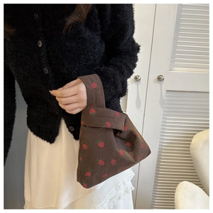Détail du sac à main en velours côtelé imprimé fraises avec texture douce et poignée