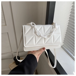 Détail du sac bandoulière matelassé blanc avec chaîne en plastique et sangle en similicuir