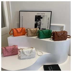 Détail de sacs bandoulière matelassés colorés avec chaînes décoratives sur un présentoir