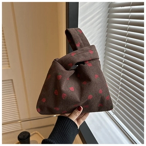 Détail d'un sac vintage en velours côtelé à imprimé fraise avec fermeture à nœud unique
