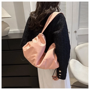 Pink slouchy cloud tote bag worn with a black tweed jacket showing large capacity