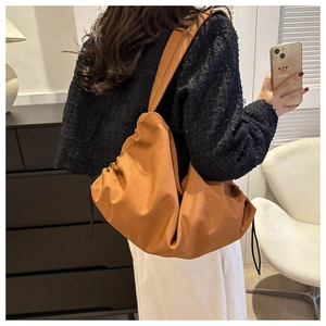 Detailed view of casual orange nylon tote bag with drawstring on a female model