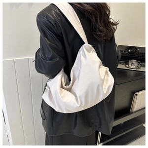 Detail of a cream pleated cloud tote bag showing soft texture and large capacity