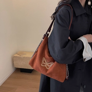 Caramel suede tote bag with butterfly embroidery and chain leather strap on model