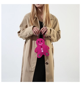 Detail of cute gingerbread man felt handbag in vibrant pink with colorful embroidery
