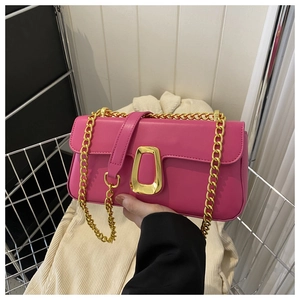 Close-up of bright pink faux leather handbag with chunky gold chain and metal buckle
