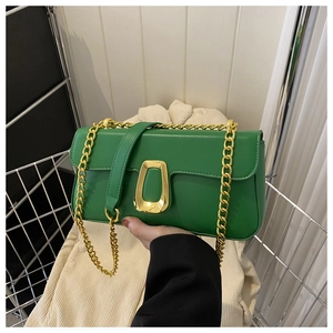 Detail of green PU leather crossbody bag featuring gold chain and trapezoid buckle