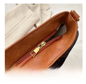 Détail de la fermeture éclair fluide et de la doublure géométrique du sac seau marron chic