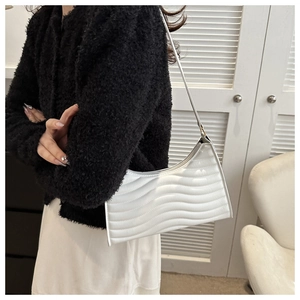 Detail of white glossy underarm bag with wave quilted pattern and slim shoulder strap