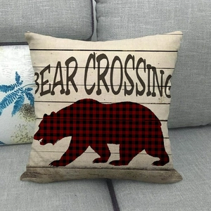 Housse de coussin en lin avec texte Bear Crossing et silhouette d'ours rouge sur sofa