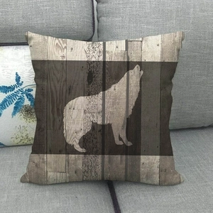 Détail de la housse de coussin en lin avec silhouette de loup sur fond de grain de bois