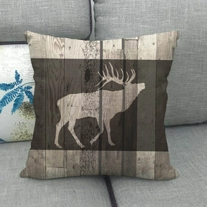 Détail d'une housse de coussin en lin avec silhouette de cerf sur motif grain de bois