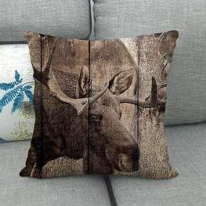 Linen moose throw pillow cover with vintage wood board print on a grey sofa
