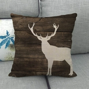 Détail de la housse de coussin en lin avec motif grain de bois et silhouette de cerf