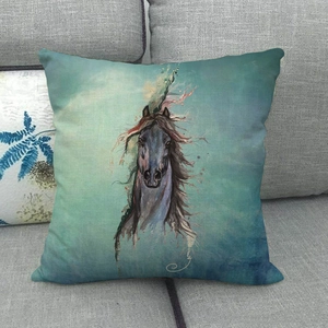 Close-up of linen throw pillow featuring a dynamic blue horse art print on a grey sofa